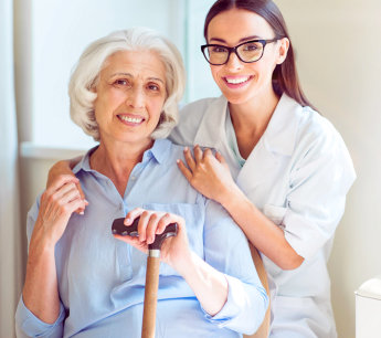 Caregiver and elderly woman smiling together